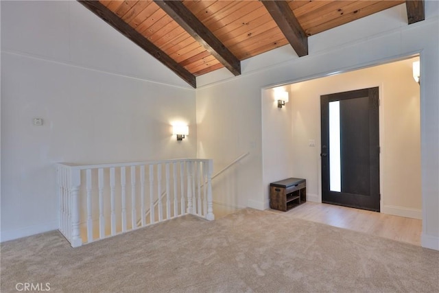 carpeted empty room featuring lofted ceiling with beams and wooden ceiling