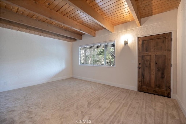 spare room with carpet floors, wooden ceiling, and beam ceiling