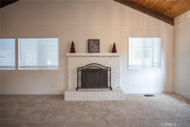 unfurnished living room featuring vaulted ceiling with beams, wood ceiling, a fireplace, and carpet flooring