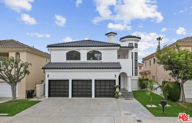 mediterranean / spanish-style house with a garage and a front yard