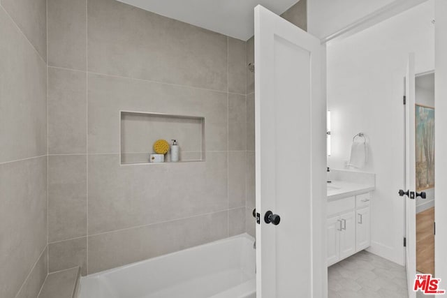 bathroom featuring vanity and tiled shower / bath