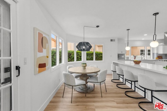 dining space featuring sink and light wood-type flooring