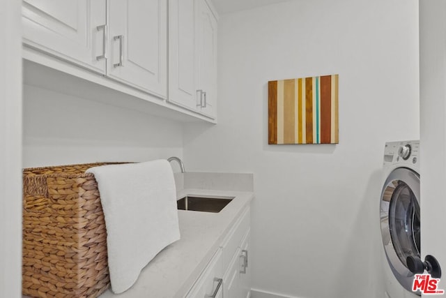 laundry area with cabinets, washer / clothes dryer, and sink