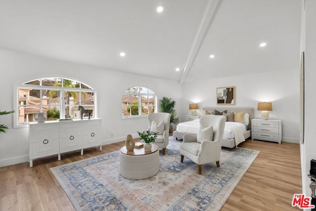 bedroom with vaulted ceiling with beams and light hardwood / wood-style flooring