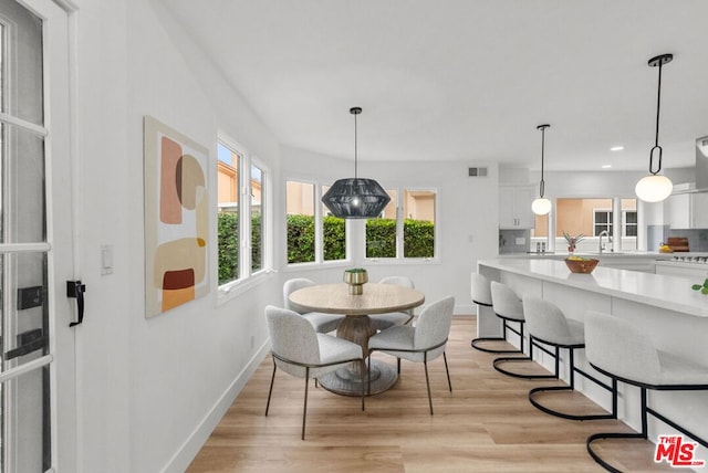 dining room featuring sink and light hardwood / wood-style floors