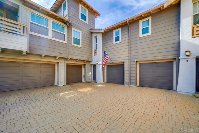 townhome / multi-family property with driveway and an attached garage