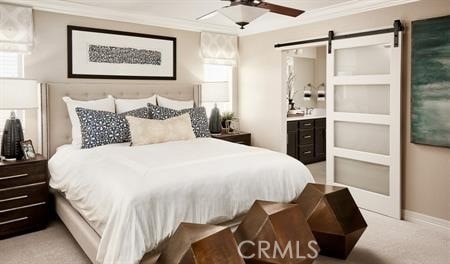 bedroom featuring ensuite bath, ornamental molding, a barn door, and light carpet