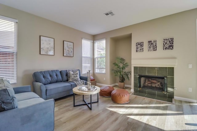 living room with hardwood / wood-style floors and a tile fireplace