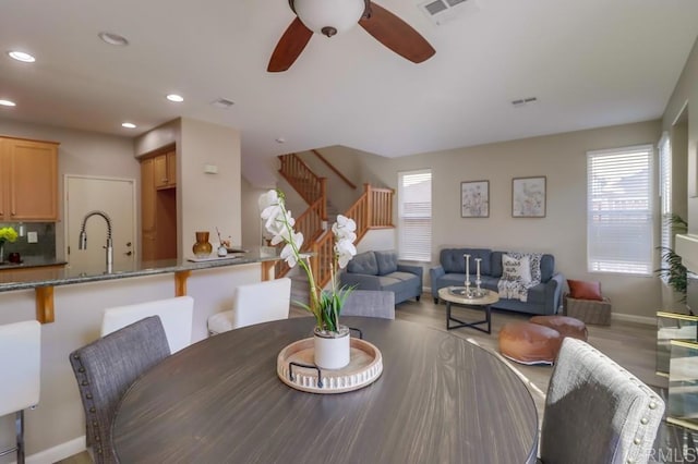 dining room with ceiling fan, sink, and hardwood / wood-style floors