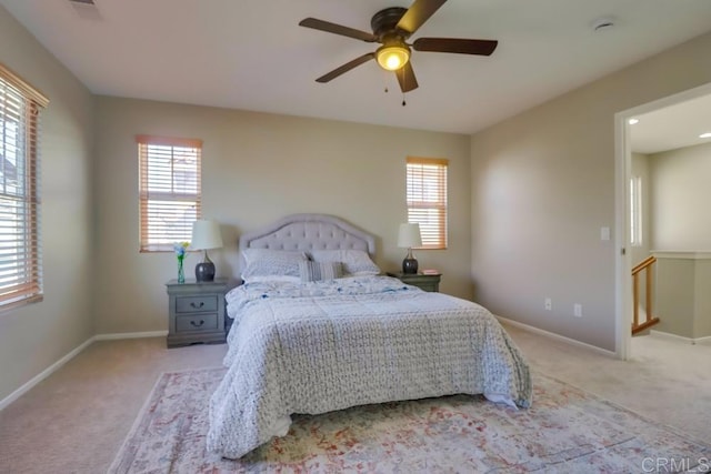 bedroom with multiple windows, light colored carpet, and ceiling fan