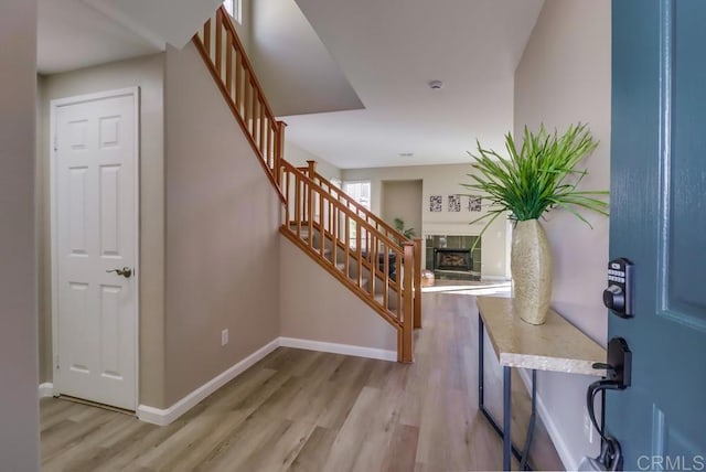 foyer featuring a tile fireplace and light hardwood / wood-style flooring