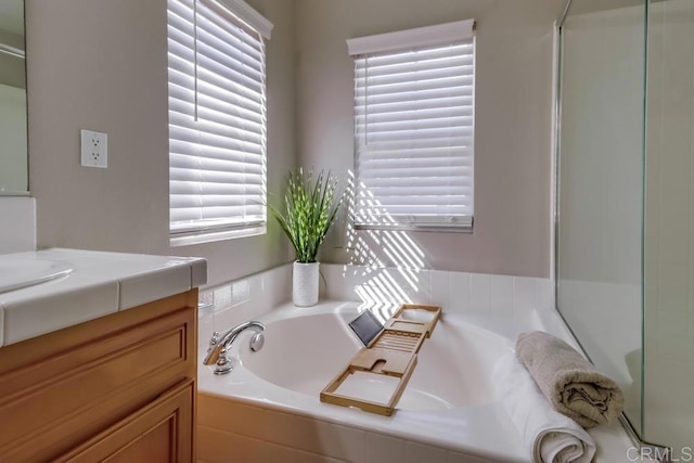 bathroom featuring vanity, independent shower and bath, and a healthy amount of sunlight