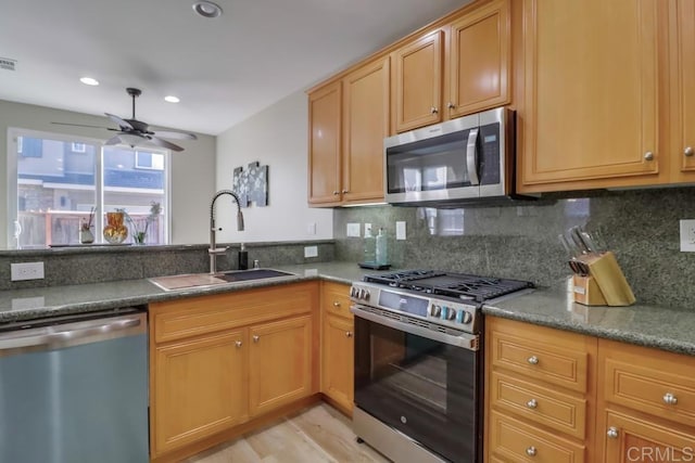 kitchen featuring tasteful backsplash, ceiling fan, appliances with stainless steel finishes, and sink