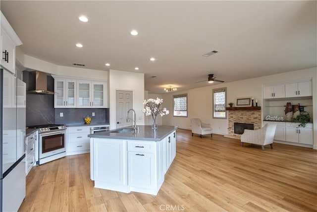 kitchen with white cabinetry, gas stove, and wall chimney exhaust hood