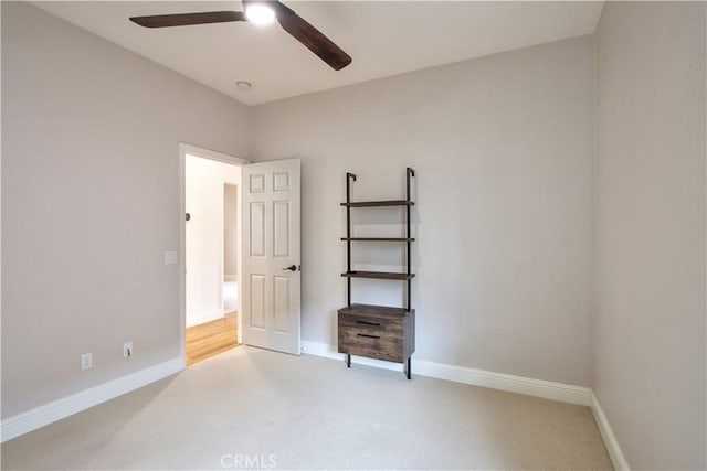 unfurnished bedroom with ceiling fan and light colored carpet