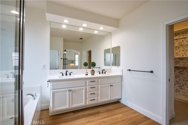 bathroom with hardwood / wood-style flooring, vanity, and independent shower and bath