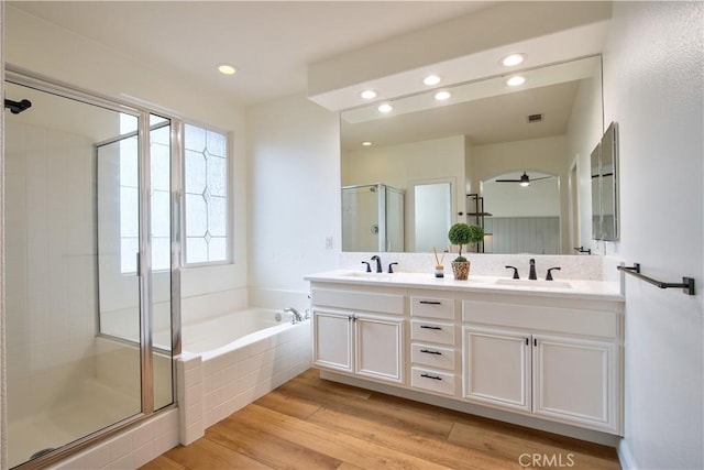 bathroom with vanity, hardwood / wood-style flooring, and plus walk in shower