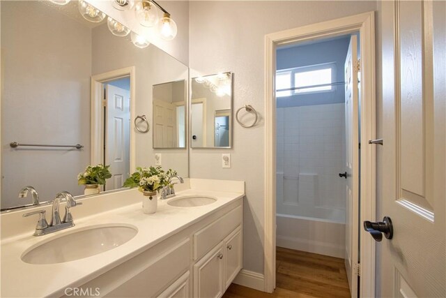 bathroom featuring hardwood / wood-style flooring, vanity, and shower / bath combination