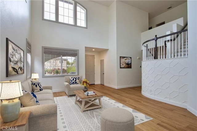 living room with hardwood / wood-style floors, a high ceiling, and a wealth of natural light