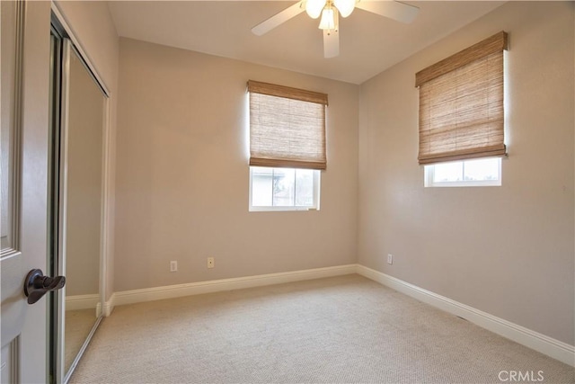 spare room with light colored carpet and ceiling fan