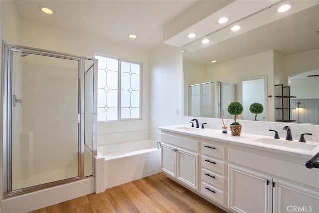 bathroom featuring independent shower and bath, vanity, and hardwood / wood-style flooring