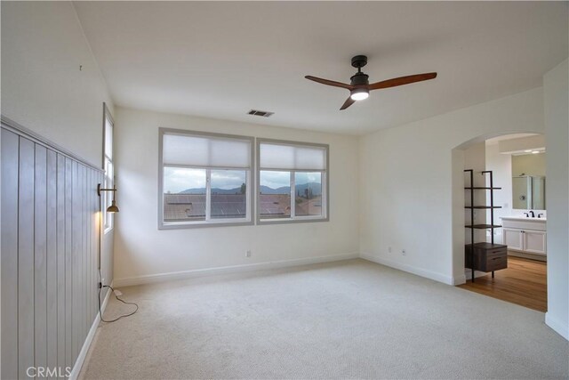 interior space with ceiling fan and light carpet