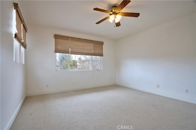 spare room featuring ceiling fan and light carpet