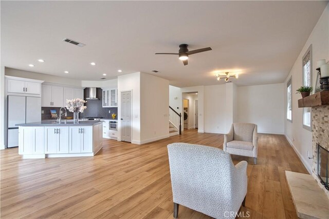 living room featuring washer / dryer, light hardwood / wood-style flooring, and ceiling fan