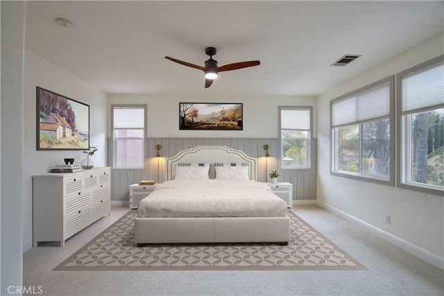 bedroom with multiple windows, light carpet, and ceiling fan