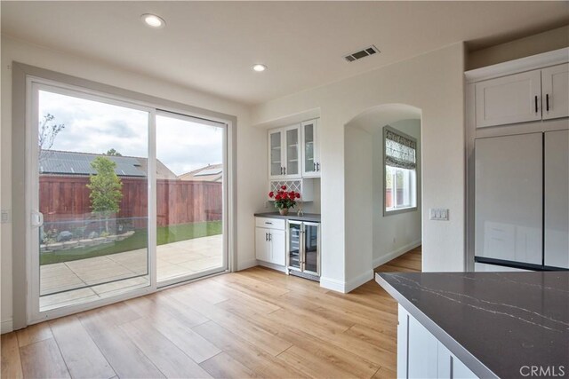 doorway featuring bar area, wine cooler, and light hardwood / wood-style floors