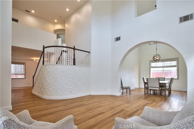 interior space featuring a high ceiling, a chandelier, and light hardwood / wood-style flooring