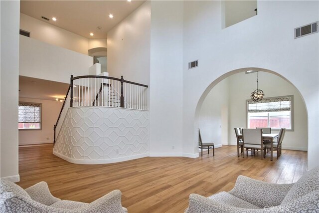 living room with visible vents, stairway, and wood finished floors