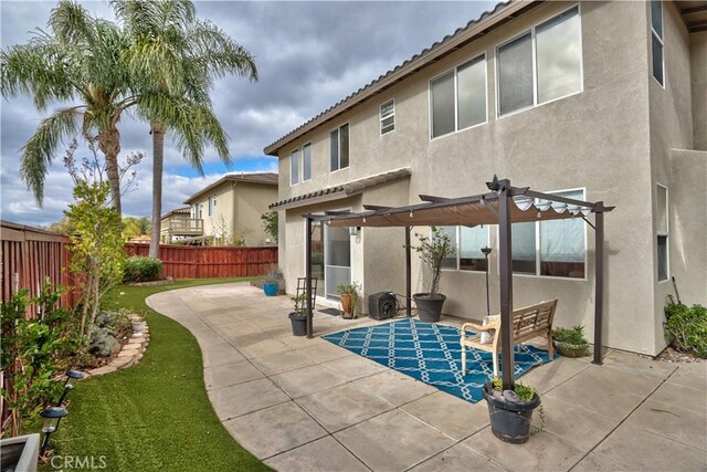 rear view of house featuring a pergola and a patio