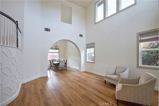 living area with light hardwood / wood-style flooring and a high ceiling