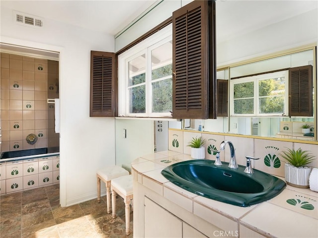 bathroom featuring vanity, a bath, and decorative backsplash