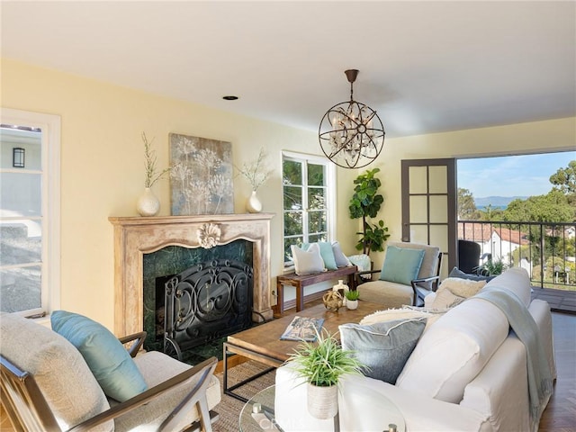 living room with hardwood / wood-style flooring, a chandelier, and a fireplace