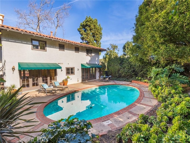 view of swimming pool with a patio and french doors