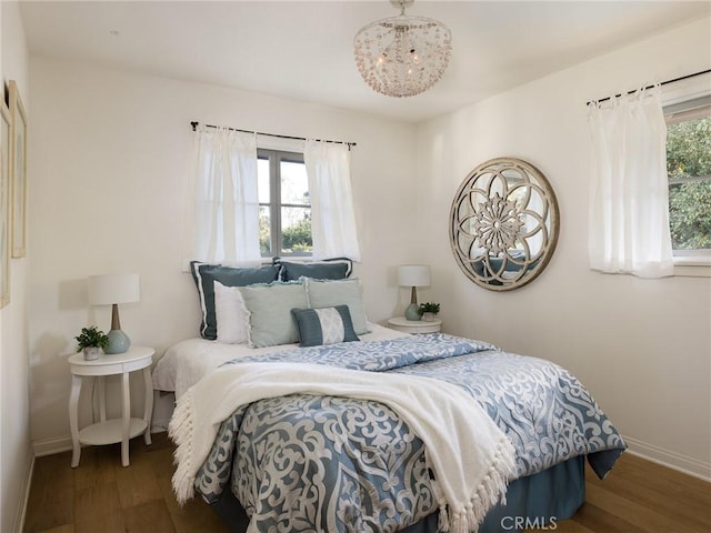 bedroom featuring multiple windows and dark hardwood / wood-style floors