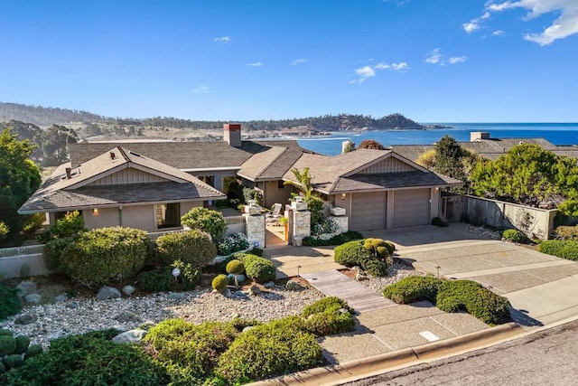 view of front of property with a garage and a water view