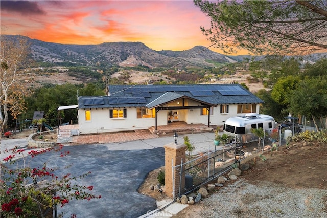 view of front of house with a mountain view and solar panels