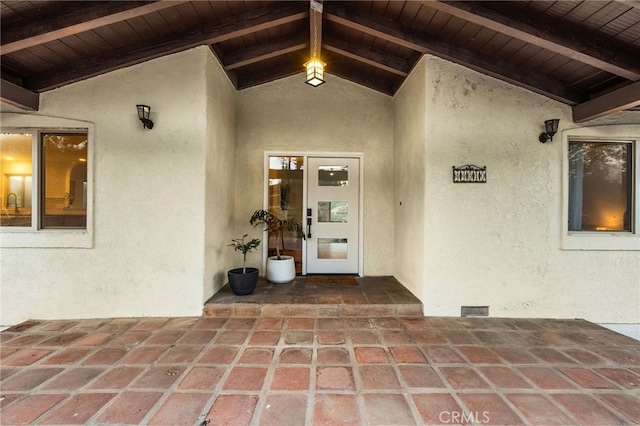 view of exterior entry with a patio