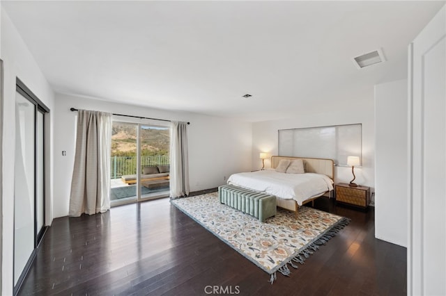 bedroom with dark hardwood / wood-style floors and access to outside