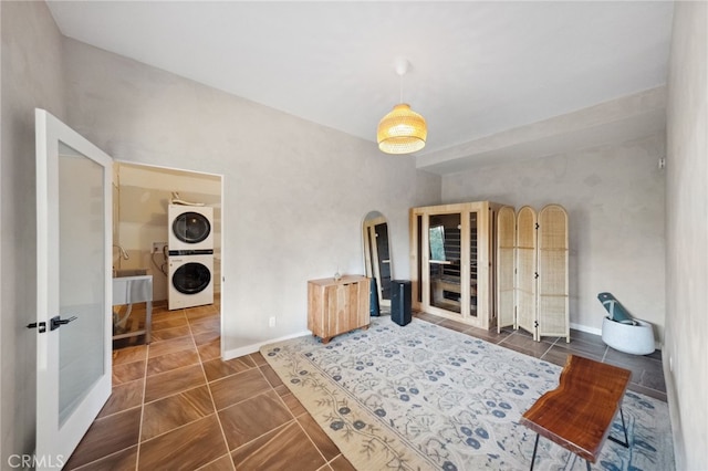 interior space featuring stacked washer / dryer and dark tile patterned floors