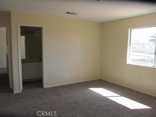 unfurnished bedroom featuring baseboards, visible vents, and carpet flooring