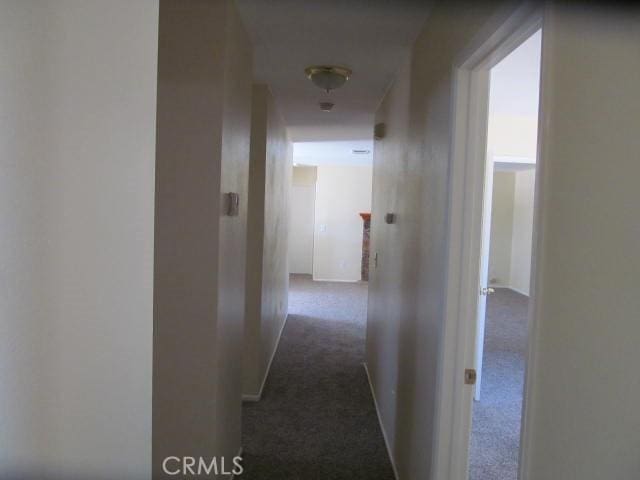 hallway featuring dark carpet