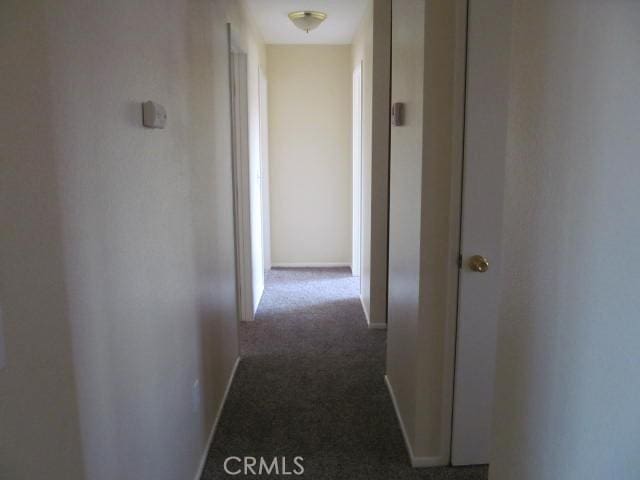 hall featuring carpet floors and baseboards