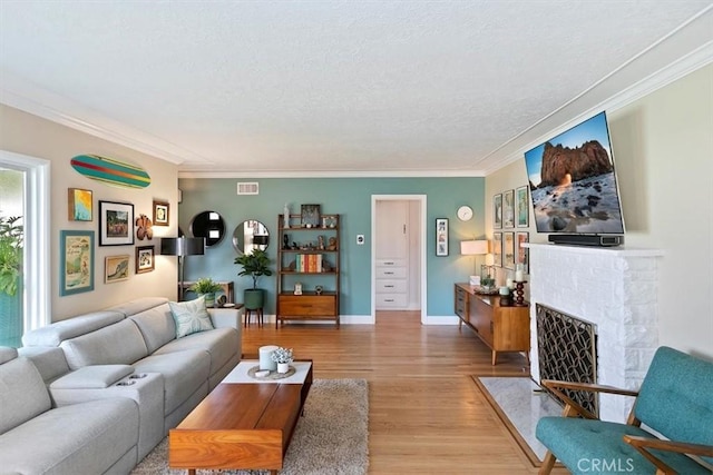 living room with wood-type flooring, ornamental molding, and a textured ceiling