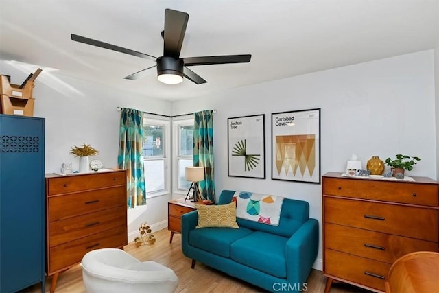 living area with ceiling fan and light hardwood / wood-style flooring