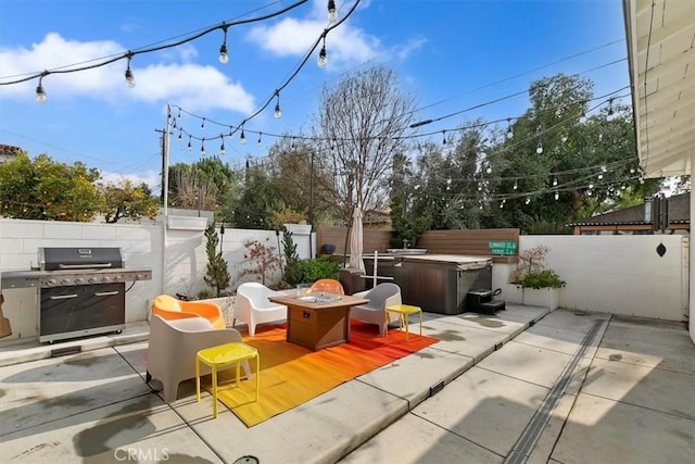 view of patio / terrace with area for grilling, a hot tub, and a fire pit