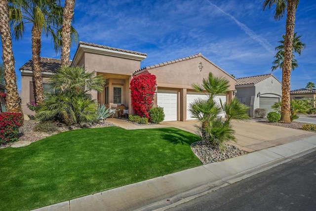 mediterranean / spanish house with a garage and a front lawn